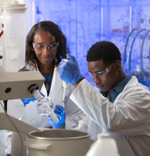 Dr. Gymama屠杀 in her lab with a student researcher